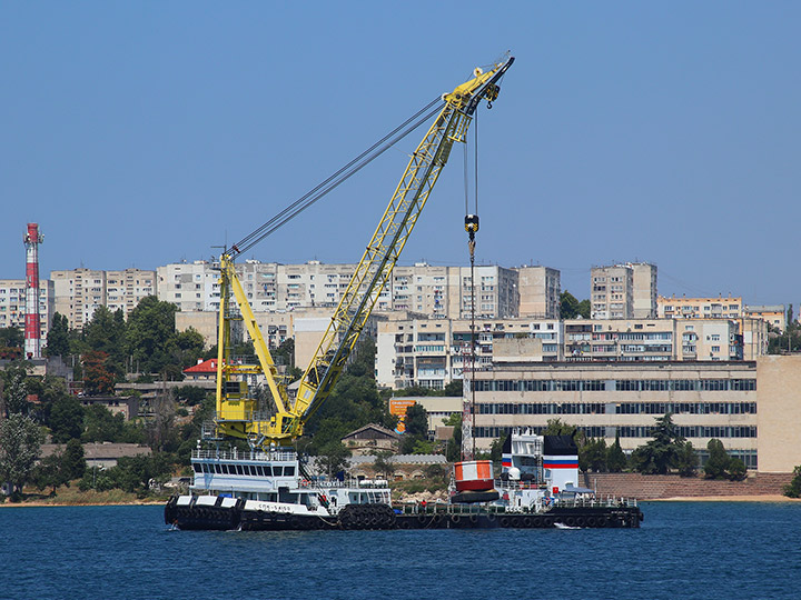 Самоходный плавучий кран СПК-54150 за работой с рейдовым оборудованием в Севастополе